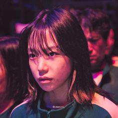 a woman with long hair sitting next to other people