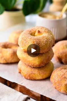 donuts stacked on top of each other in front of a bowl of dipping sauce