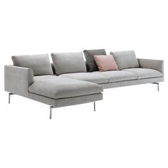 a large sectional couch with pillows on it's back and side ends, sitting against a white background