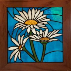 a stained glass window with three white daisies