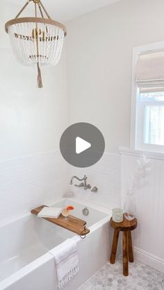 a bathroom with a chandelier hanging from the ceiling and a white bathtub