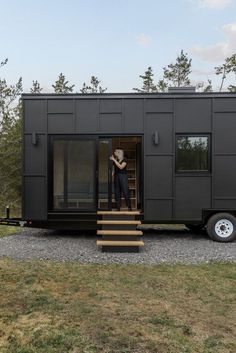 a person standing in the doorway of a tiny house