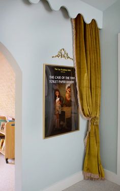 a movie poster hangs on the wall next to a yellow drapes in a child's bedroom