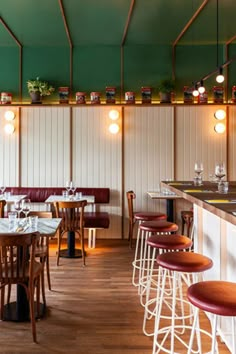 the interior of a restaurant with wooden tables and stools