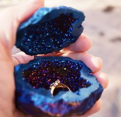 two pieces of blue and purple rock with a ring on it's middle finger