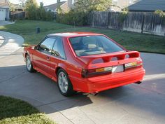 a red car is parked on the driveway