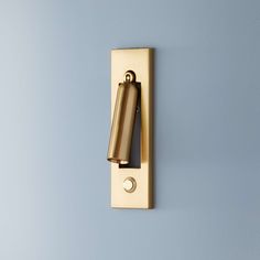 a wall mounted light switch on the side of a blue wall with a black handle