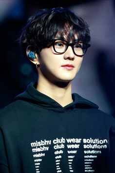 a young man wearing glasses and a hoodie with words written on the side of it