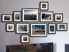 a television sitting in front of a bunch of framed pictures on the wall next to a flat screen tv