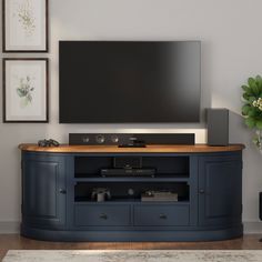 a flat screen tv sitting on top of a wooden entertainment center