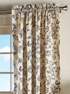 a window with a curtain that has blue flowers on it and is next to a window sill