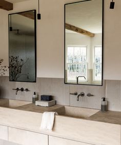 a bathroom with two sinks and mirrors on the wall