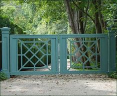 a blue gate in front of some trees