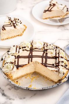 there is a pie on the table with one slice taken out and two plates behind it