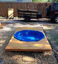 a blue bowl sitting on top of a wooden pallet in the middle of a yard