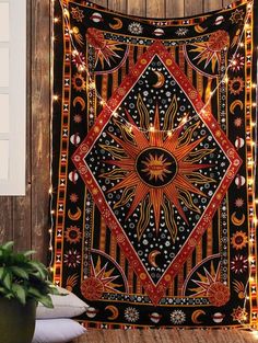 a tapestry hanging on the side of a wooden wall with string lights and a potted plant