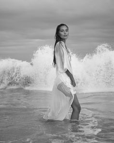 a woman standing in the water at the beach