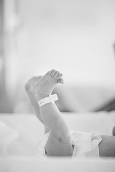 a black and white photo of a baby's foot with a bandage on it