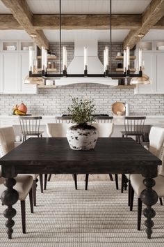 the dining room table is surrounded by white chairs