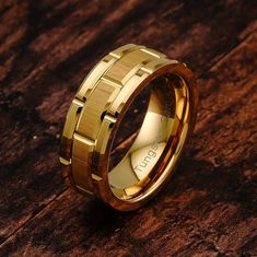 a gold wedding ring on top of a wooden table