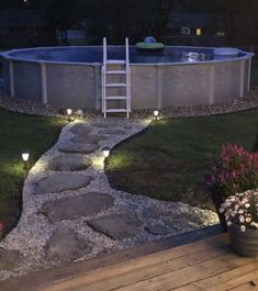 an above ground swimming pool with steps leading up to it and lights on the side