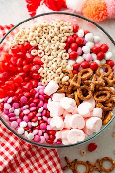 a bowl filled with candy and pretzels on top of a checkered table cloth