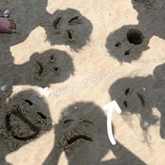 several people standing in the sand with their shadows on them