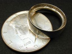 two silver rings sitting on top of a coin