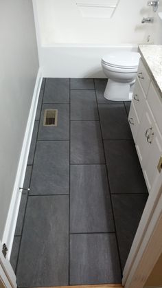 a white toilet sitting in a bathroom next to a sink