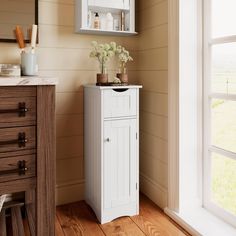 a white cabinet sitting in the corner of a room