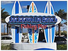 a sign for jacksonville beach fishing pier with surfboards sticking out of it's sides