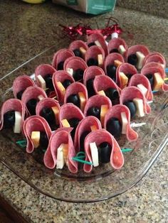 an assortment of appetizers are arranged on a glass platter with toothpicks and olives