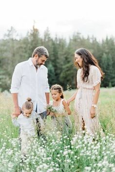 an adult and two children are standing in tall grass