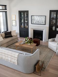 a living room filled with furniture and a fire place in the middle of a room