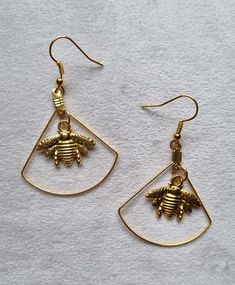 Gold-colored geometric bee earrings. Geometric Bee, Bee Earrings, Jewelry Earrings Dangle, Gold Color, Dangle Drop Earrings, Dangle Earrings, Bee, Jewelry Earrings, Drop Earrings