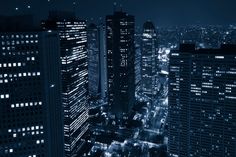 cityscape at night with skyscrapers lit up in black and white, as seen from above