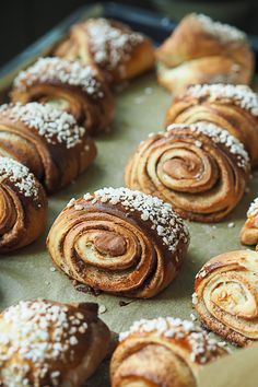 many different types of pastries on a baking sheet with powdered sugar sprinkles