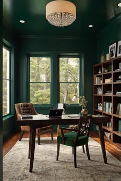 a home office with green walls and wooden floors, along with a large window that has lots of bookshelves