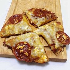 four slices of pizza on a wooden cutting board