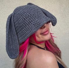 a woman with pink hair wearing a gray crochet hat