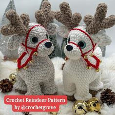 two crocheted reindeers with bells on their heads are sitting next to each other