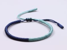 two blue and green bracelets on a white surface