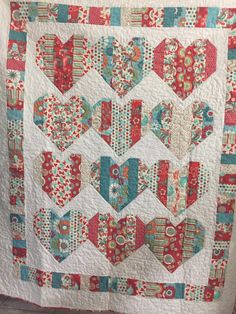 a red and white quilt with hearts on it