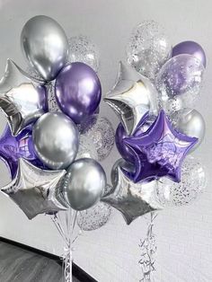 purple and silver balloons are arranged in the shape of a star on top of each other