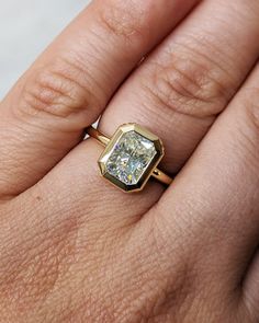 a woman's hand with a ring on it and a diamond in the middle