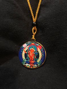 a person wearing a necklace with an image of a buddha in the center on it