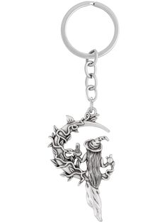 a metal key chain with an image of a man on the moon and tree branches