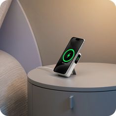 an iphone charging on top of a nightstand