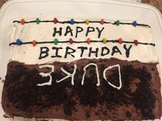 a birthday cake with white frosting and brown icing