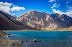 the mountains are covered in snow and blue water